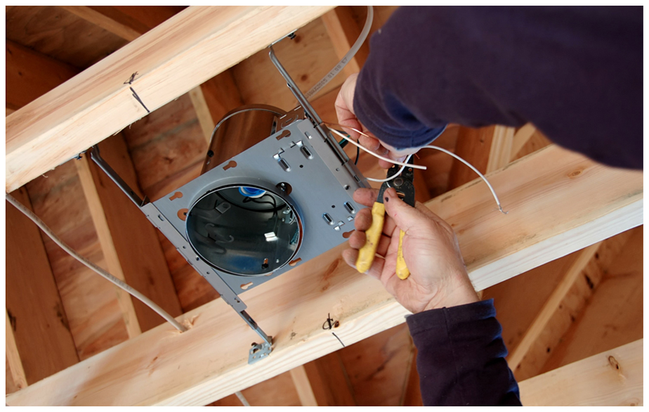 Electrician fixing a a light fixture in ceiling